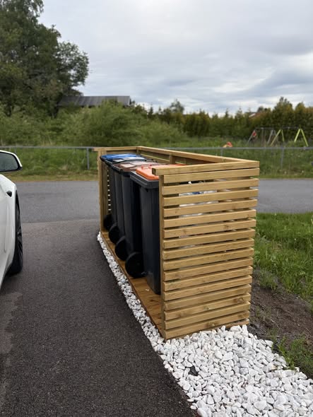Detalj av søppeldunkhus med trelameller